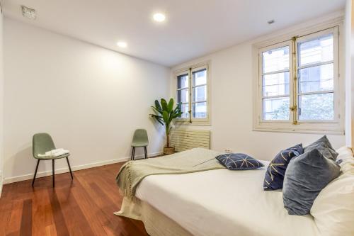 マドリードにあるCentrico apartamento en las inmediaciones de Gran Víaの白いベッドルーム(ベッド1台、窓2つ付)