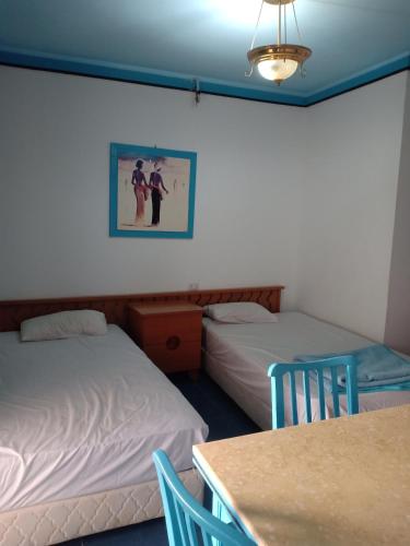 two beds in a room with a table and chairs at A two-room chalet in the village of Lale Land, Mirage Bay, Ecopark in Hurghada