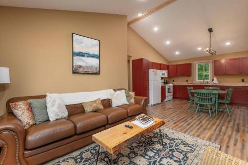 a living room with a brown couch and a kitchen at Wilderness Meadows in Pine City