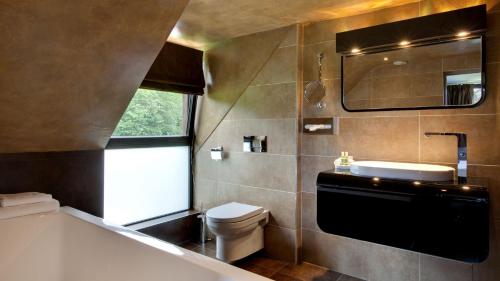 a bathroom with a tub and a toilet and a sink at Le Pavillon De Gouffern in Silly-en-Gouffern