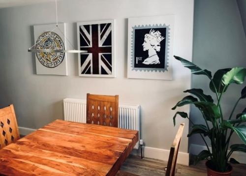 a dining room with a wooden table and pictures on the wall at Plymouth city centre apartment near Theatre Royal in Plymouth