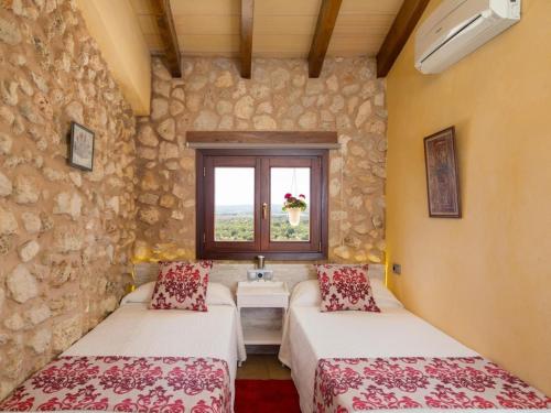 a room with two beds and a sink and a window at Casa del Sol in Búger