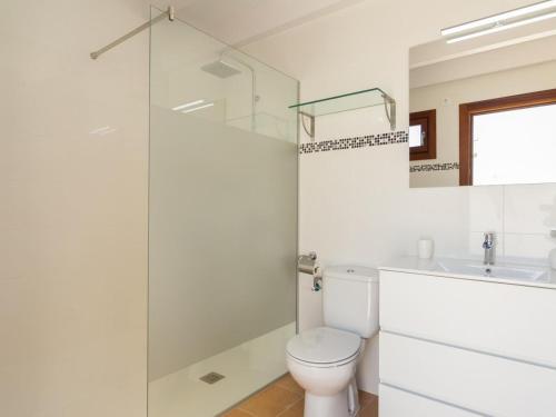 a bathroom with a toilet and a glass shower at Casa del Sol in Búger