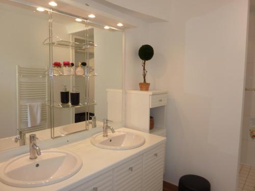 La salle de bains est pourvue de 2 lavabos et d'un miroir. dans l'établissement La Suite Le Nôtre, à Colleville-sur-Mer