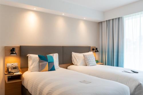 a hotel room with two beds and a telephone at Holiday Inn - Bordeaux-Merignac by IHG in Mérignac