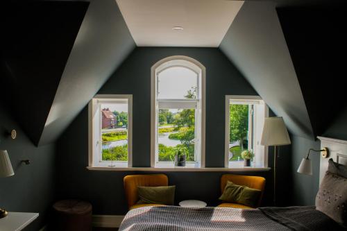 a bedroom with two windows and a bed at Hostrups Hotel in Tønder