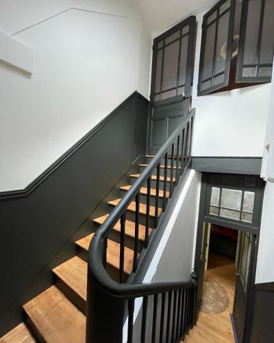 a staircase with black and white walls and wooden floors at Demeure de charme in Lons-le-Saunier