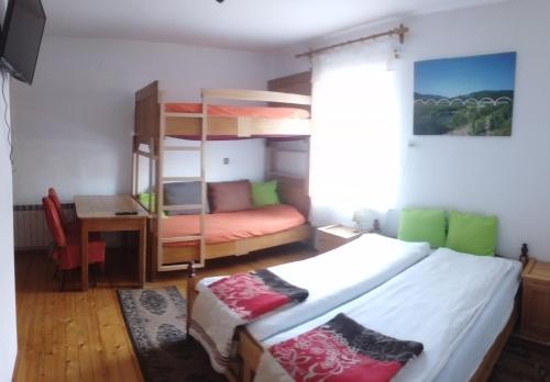 a bedroom with a bunk bed and a desk at Królówka in Maków Podhalański