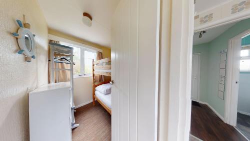 a small room with a bunk bed and a bedroom at E17 Glenvale, Riviere Towans in Hayle