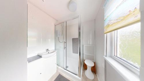 a bathroom with a sink and a toilet and a window at E17 Glenvale, Riviere Towans in Hayle