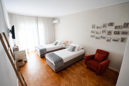 a hotel room with two beds and a chair at Alegria Cozy com Terraço - Centro do Porto in Porto