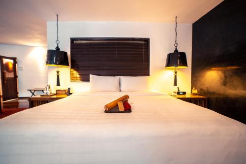 a bedroom with a white bed with two lamps at Villa Samadhi by Samadhi Age 12 and Above Only in Kuala Lumpur