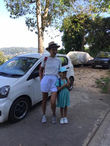 a woman and a little girl standing next to a car at Funk Bunks - Mount View in Kandy