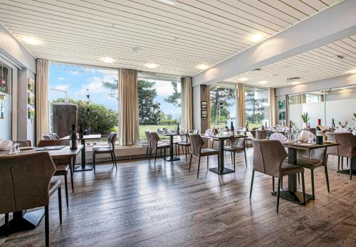 - une salle à manger avec des tables, des chaises et des fenêtres dans l'établissement Hotel/ Apartments Marina, à Grenå