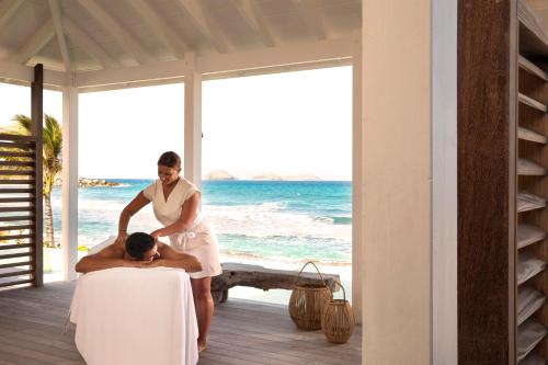 a man getting a massage at the beach at Hotel Manapany in Gustavia