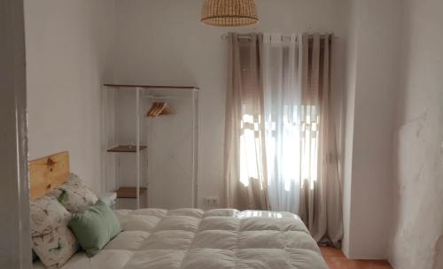 a bedroom with a bed and a large window at Casa Lucas in Grazalema