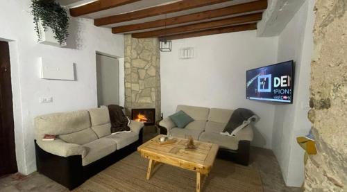 sala de estar con sofá, mesa y TV en Casa Lucas, en Grazalema