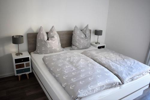 a white bed with pillows on top of it at 50 3 N Nordkoje in Wangerland
