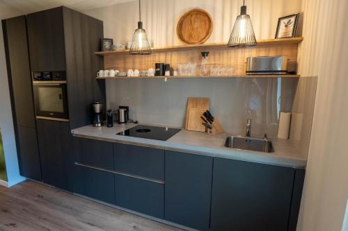uma cozinha com armários azuis e um lavatório em Ferienwohnung Rathausblick 2 mit Infrarot-Kabine em Blankenburg