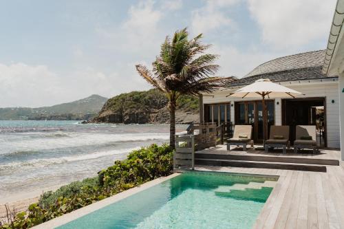 une maison avec une piscine à côté de la plage dans l'établissement Hotel Manapany, à Gustavia