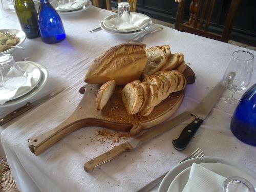 a table with a cutting board with bread on it at Cascina La Commenda in Peveragno