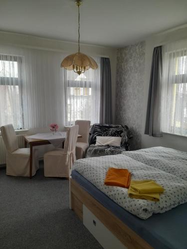 a bedroom with a bed and a dining room at Pension Edelweiß in Kurort Gohrisch
