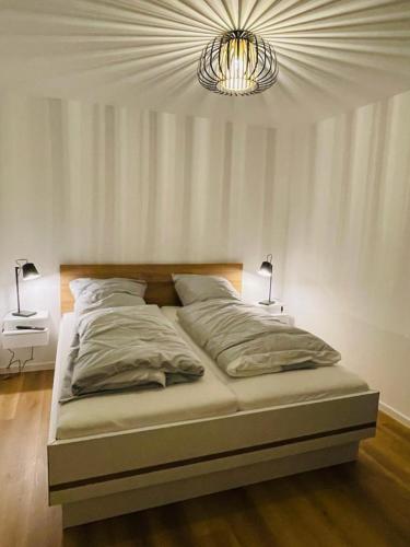 a bedroom with a bed with a chandelier above it at 49 5 M Ankerplatz in Wangerland