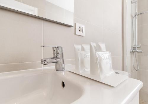 a white bathroom with a sink and a mirror at Moderno apartamento urbano en barrio histórico 3ºD in Santa Cruz de Tenerife