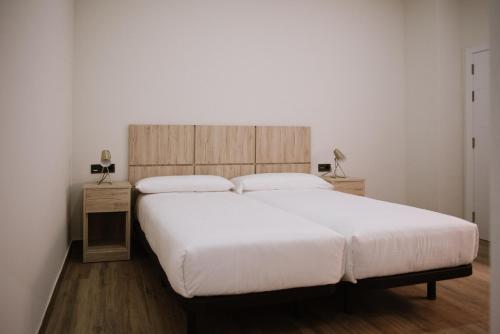 a bedroom with a large bed with a wooden headboard at Hotel Melilla Centro in Melilla