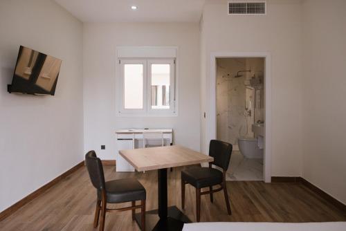 a room with a table and chairs and a bathroom at Hotel Melilla Centro in Melilla