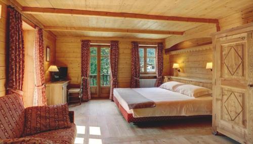 Hotel Breithorn في تشامبولوك: غرفة نوم بسرير في غرفة خشبية
