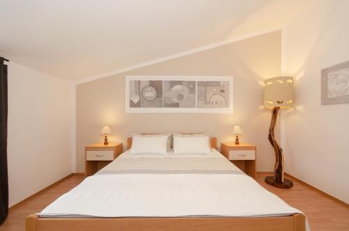 sypialnia z łóżkiem i 2 szafkami nocnymi w obiekcie Apartments Villa Amfora w Rovinj