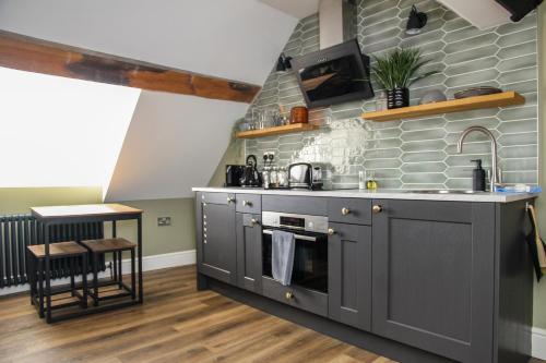 a kitchen with gray cabinets and stainless steel appliances at no 12 - Stunning Self Check-in Apartments in Worcester Centre in Worcester