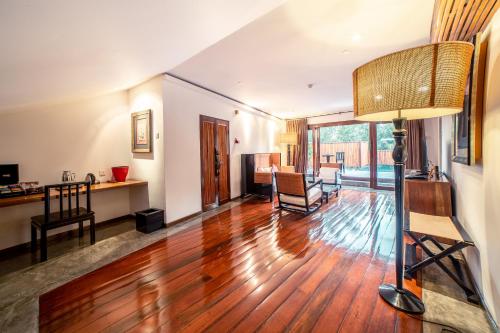 a living room with a wooden floor and a lamp at Villa Samadhi by Samadhi Age 12 and Above Only in Kuala Lumpur