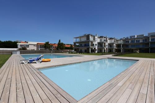 a large swimming pool on a wooden deck next to a building at T2-Marina Mar-Condomínio de Luxo in Nazaré