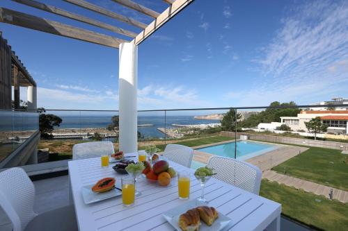 a white table with food on top of a balcony at T2-Marina Mar-Condomínio de Luxo in Nazaré