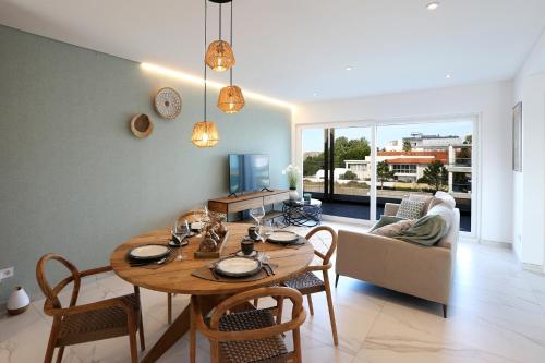 a dining room and living room with a table and chairs at T2-Marina Mar-Condomínio de Luxo in Nazaré