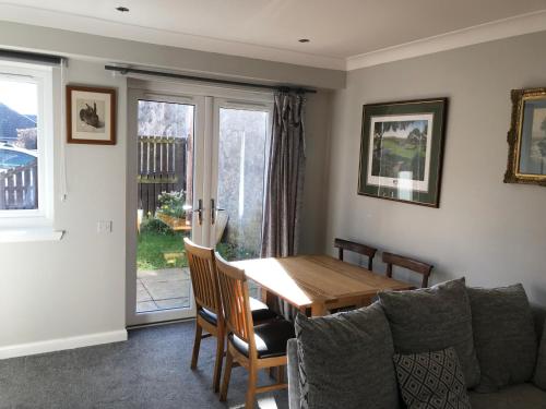 a dining room with a table and a couch at 2 The Old Scout Hall in Blairgowrie