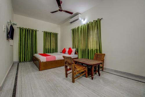 1 dormitorio con 1 cama, mesa y sillas en OYO Flagship Corporate Club, en Ranchi