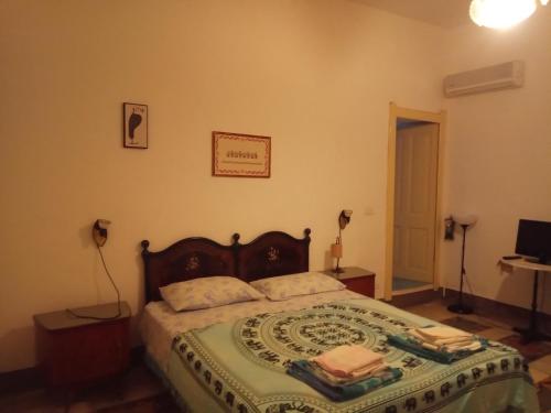 1 dormitorio con 1 cama con manta verde y blanca en Sa Pruninca en Villanova Monteleone