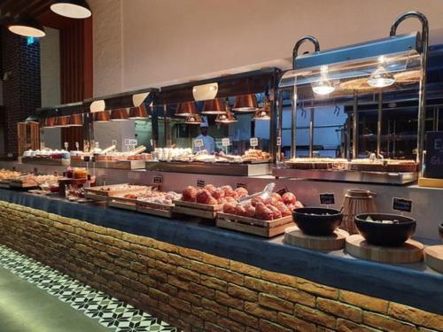a buffet line in a restaurant with meats and food at Fashion Avenue Dubai Mall Highest Floor Burj Khalifa View Residence- Formerly Address Dubai Mall in Dubai