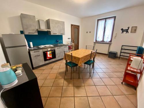 kuchnia ze stołem, krzesłami i lodówką w obiekcie Appartamento in cascina -la cascinetta di Ali- w mieście Roatto