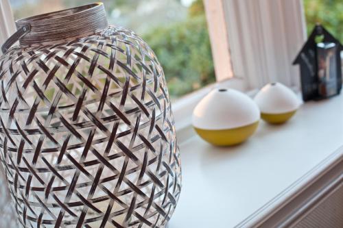 a brown and white vase sitting on a window sill at Windermere Hillthwaite Hotel in Windermere