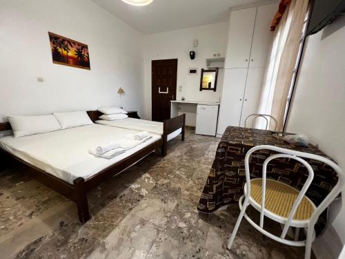 a bedroom with a bed and a table with a chair at Astra House in Paralio Astros