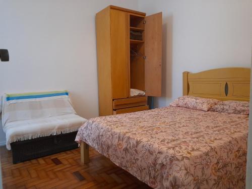 1 dormitorio con 1 cama y armario de madera en Glória' loft, en Río de Janeiro