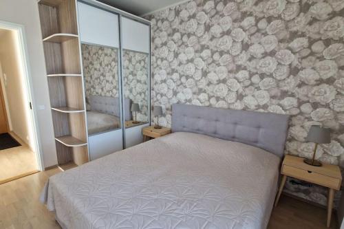 a bedroom with a bed and a wall with flowers at Modern apartment with river view in Tartu