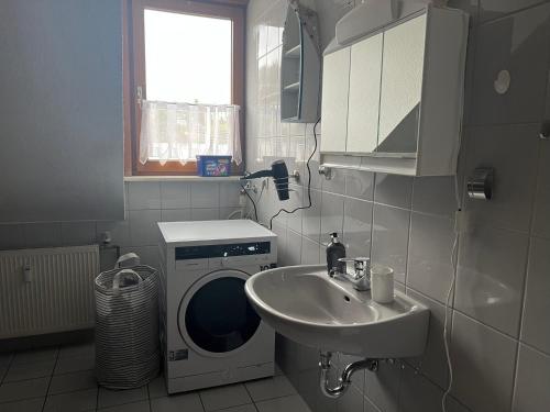 ein Badezimmer mit einer Waschmaschine und einem Waschbecken in der Unterkunft Ferienwohnung Schneider mit Balkon in Bad Laasphe