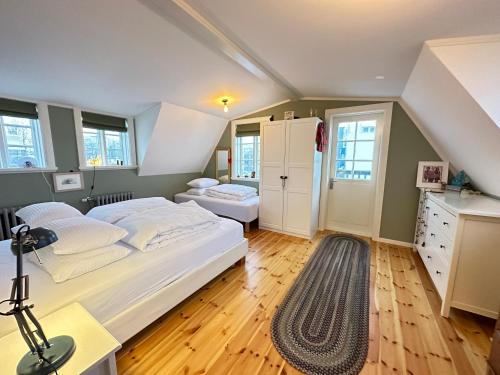a bedroom with a bed and a desk and windows at A New house that is a mix of an Historic House ( Torfhildur Hólms House ) and a new building in heart of Reykjavik on 3 levels in Reykjavík
