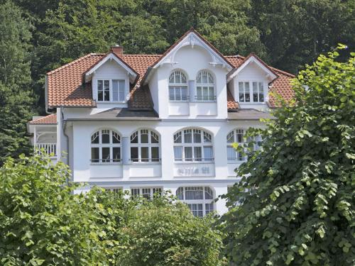 オストゼーバート・ゼリンにあるVilla Li - Fewo 01 "Herzmuschel" - F546の目の前に木々が植えられた白い家