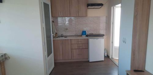 a small kitchen with a sink and a refrigerator at Petite Chambre in Velyatyn